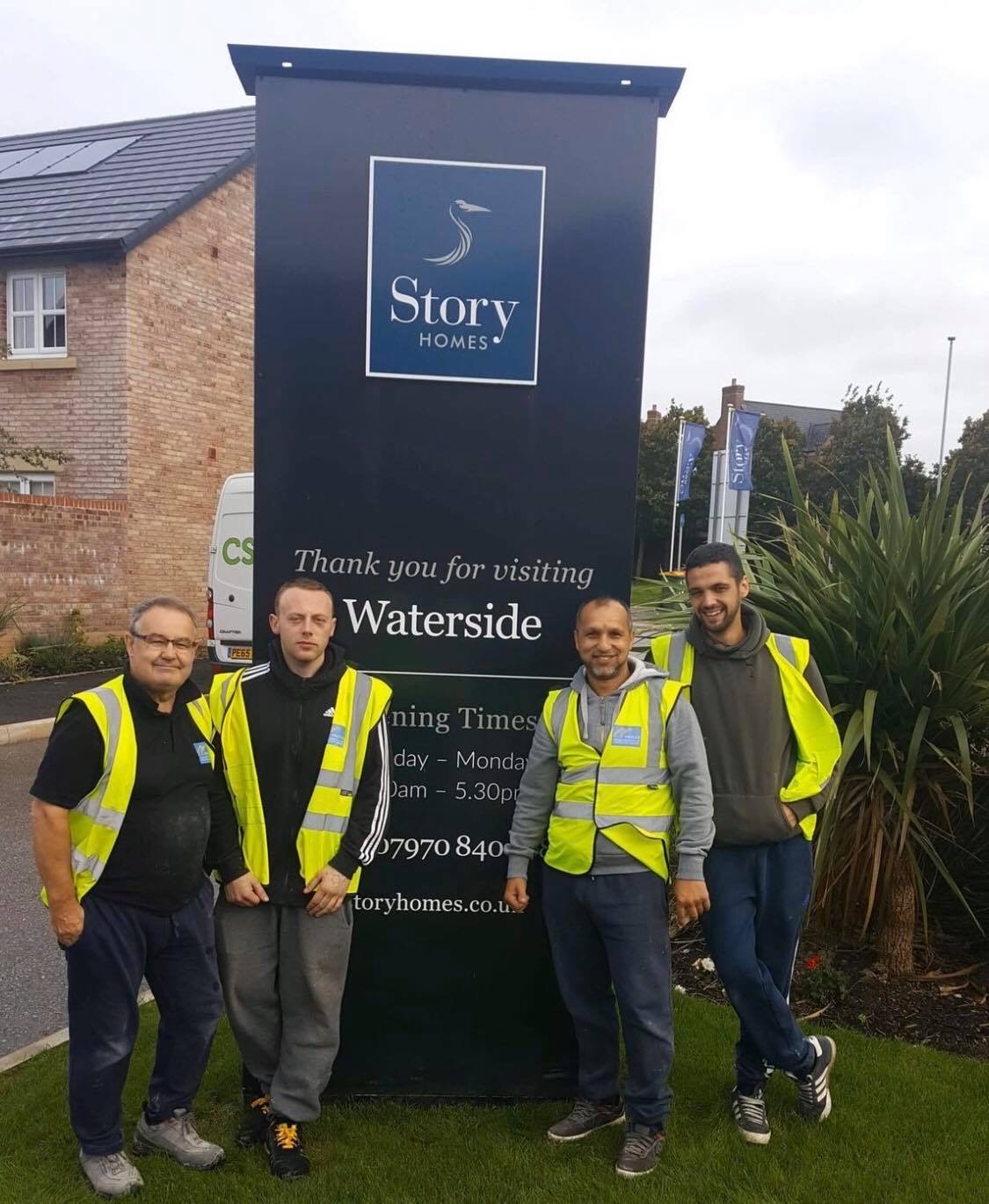 Facilco cleaning team standing in front of a developer's sign