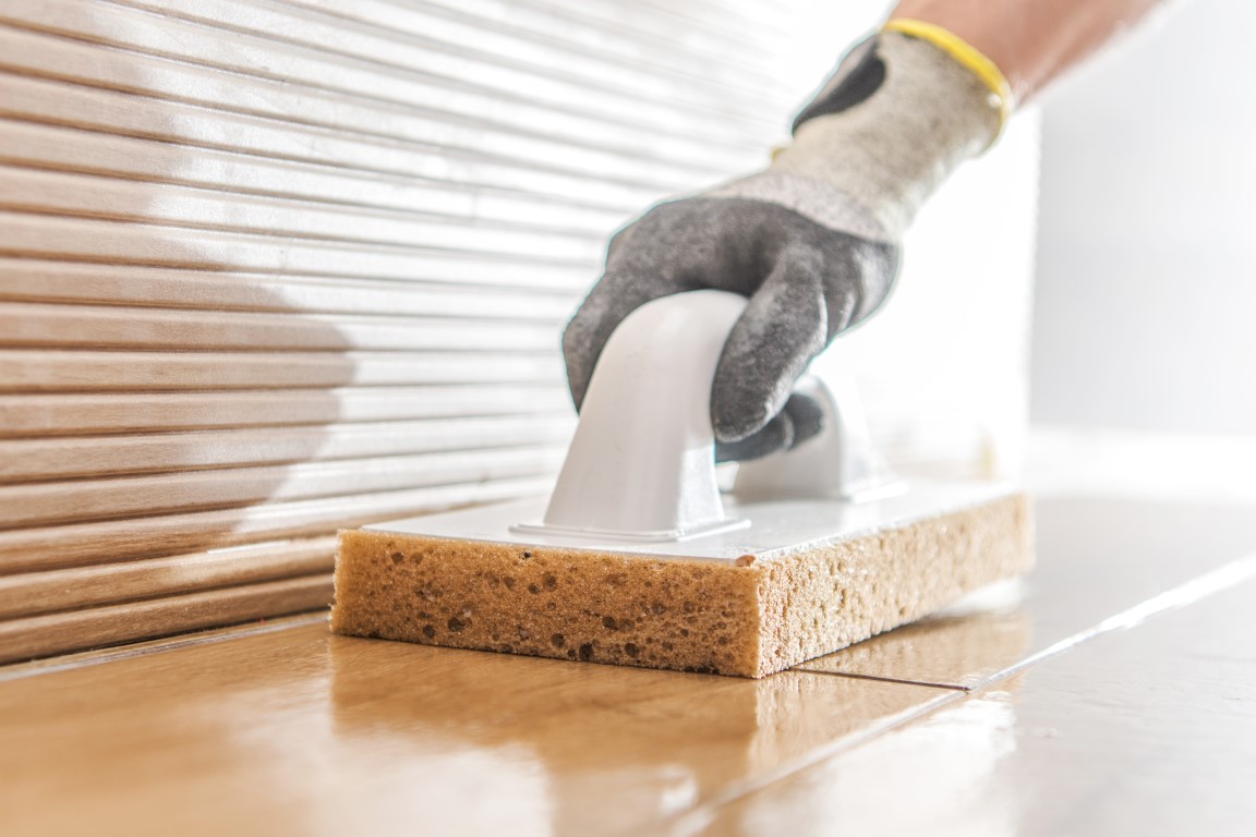 Professional cleaner cleaning tiles during construction project